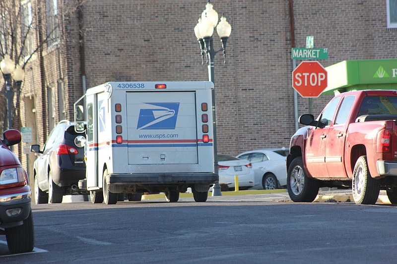 A United States Postal Service delivery truck returning to the Fulton Post Office waits to turn onto Market Street from 6th Street Wednesday afternoon. The USPS announced Wednesday that it would cease Saturday deliveries in an attempt to reduce its budget deficit.