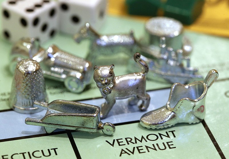 The newest Monopoly token, a cat, center, rests on Vermont Avenue next to other tokens still in use including the wheelbarrow and the shoe, at Hasbro Inc. headquarters, in Pawtucket, R.I.  Voting on Facebook determined that the cat would replace the iron token. 