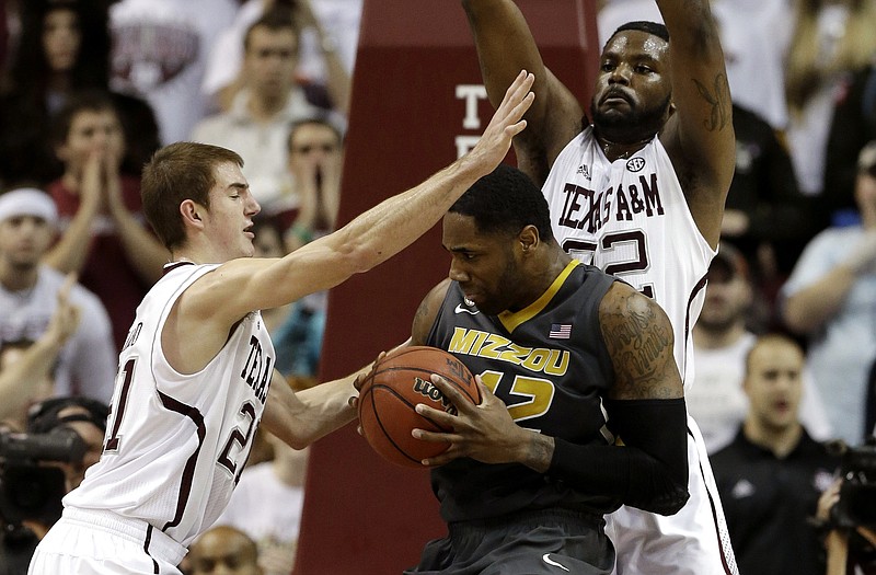 Missouri's Alex Oriakhi (42) is pressured by Texas A&M defenders Alex Caruso (21) and Kourtney Roberson (32) during the first half Thursday in College Station, Texas.