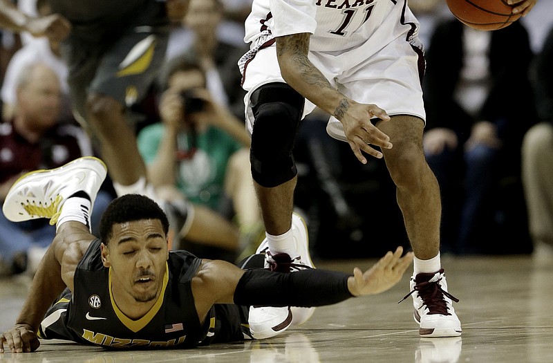 Phil Pressey of Missouri tries to get the basketball back from J'Mychal Reese of Texas A&M after a turnover in the second half of Thursday night's game in College Station, Texas.