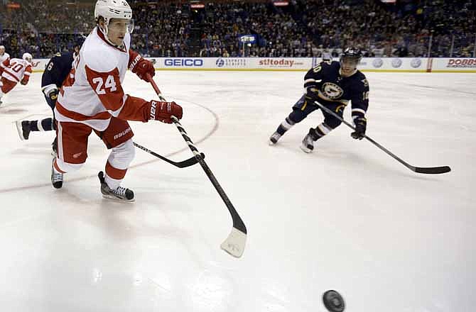 Detroit Red Wings' Damien Brunner, of Switzerland, passes the puck around St. Louis Blues' Andy McDonald, right, during the second period of an NHL hockey game Thursday, Feb. 7, 2013, in St. Louis.