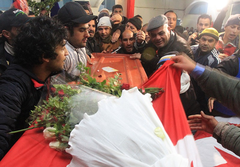 Relatives of slain opposition leader Chokri Belaid leave the house of his father while carrying the coffin prior to his funeral in Tunis, Friday. Tunisia braced for clashes on Friday, with the capital shut down by a general strike and the army deployed for Belad's funeral.