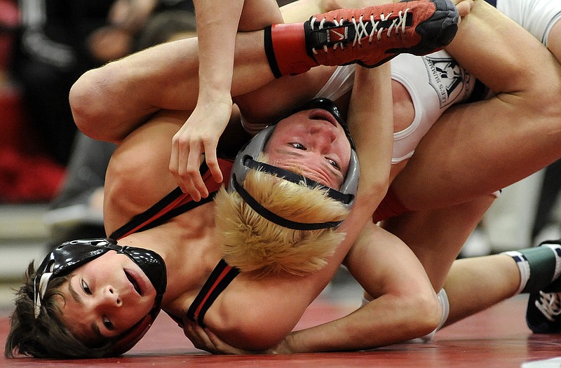 Logan Moriarity of Jefferson City (bottom) locks up with Austin Eveler of Lee's Summit West during their 120-pound championship match Saturday in the Class 4 District 3 Wrestling Tournament at Fleming Fieldhouse.