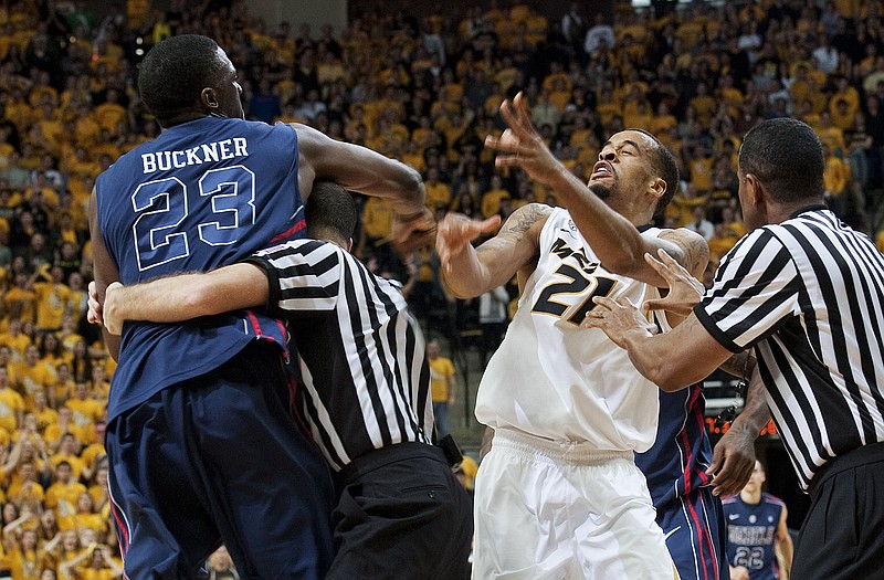 Reginald Buckner of Mississippi throws a punch at Missouri's Laurence Bowers as referees attempt to separate the players during the second half of Saturday afternoon's game at Mizzou Arena. Buckner was ejected after the fracas.
