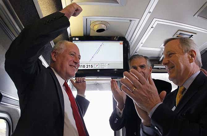 In this Oct. 19, 2012 file photo, Gov. Pat Quinn, left, U.S. Transportation Sec. Ray LaHood, center, and Sen. Dick Durbin, D-Ill., celebrate in Pontiac, Ill., after the Amtrak train they are riding reached 110 mph during a test run between Pontiac and Dwight, Ill. Hundreds of Midwest manufacturers stand to benefit from a web of high-speed passenger rail routes emerging from Chicago's rail hub, according to a report released by an environmental policy group that has fought to defend the use of billions in taxpayer money on such projects.