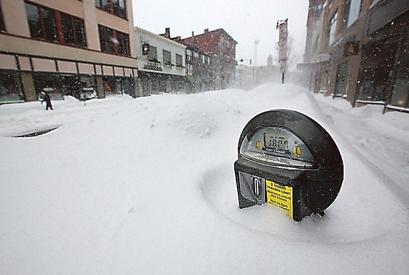 A parking meter pokes out of a snow bank after a weekend blizzard dumped more than 30 inches of snow in Portland, Maine.