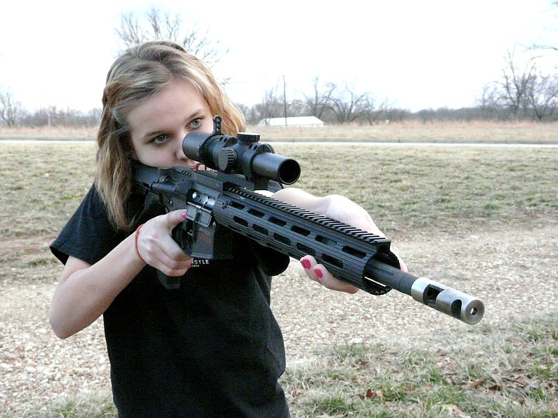 Katie Francis, 13, Saint Thomas is a typical young teenage girl. With her pink nail polish and girlish tendancies, Katie focuses in on her target while shooting her rifle in the back yard.
