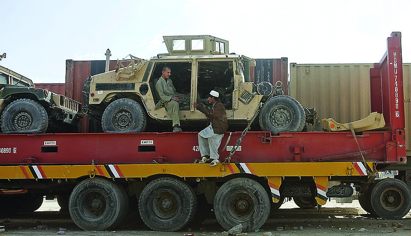 Pakistani driver assistants chat while sitting on a truck carrying NATO Humvees at a terminal on the Pakistani-Afghan border in Chaman, Pakistan. The U.S. says it has started using the land route through Pakistan to pull American military equipment out of Afghanistan.