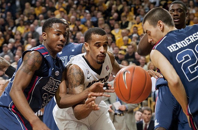 Laurence Bowers of Missouri tries to track down the ball between Misssissippi's Jarvis Summers (left) and Marshall Henderson during Saturday afternoon's game at Mizzou Arena.