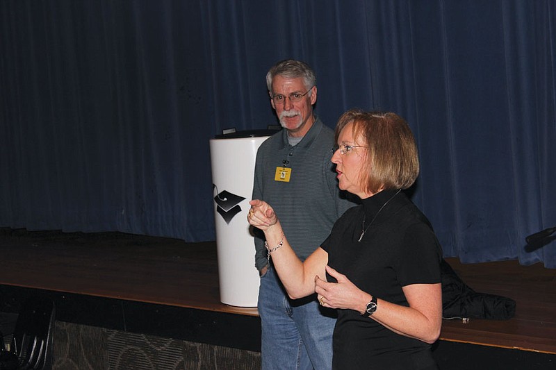 Fulton School District Board of Education member Rodney Latty and Assistant Superintendent Suzanne Hull talk with the Fulton High School Class of 2013 about the time capsule sitting on the stage in the high school auditorium Tuesday. The Class of 2013 will be the first to take part in a new tradition where graduating classes bury time capsules filled with notes, items and other memories, to dig up during their 20-year reunion.
