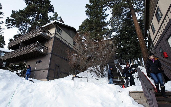 Members of the news media are shown outside a home, at left, in Big Bear, Calif., where the owners of the cabin were taken hostage by fugitive Christopher Dorner. 