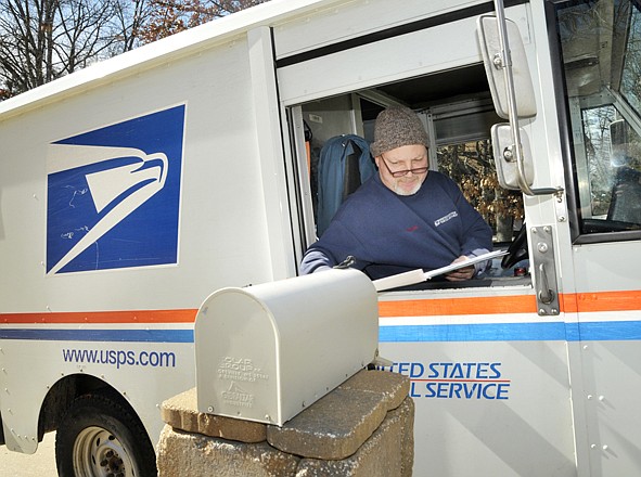 Twenty-two-year postal employee Joe McGrail delivers mail to East Side residences Thursday. To save money, the cash-strapped United States Postal Service plans to end Saturday deliveries.