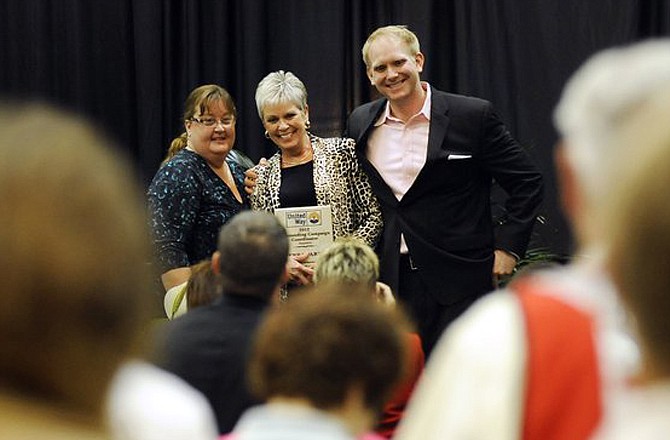 Jefferson City Public Schools' Terra Parris receives a standing ovation from the crowd as she accepts her Campaign Coordinator of the Year award from 2012 Campaign Co-Chairs Lori Massman, left, and Jake Green, right, during the United Way of Central Missouri's annual meeting and luncheon at the Capitol Plaza Hotel on Friday.