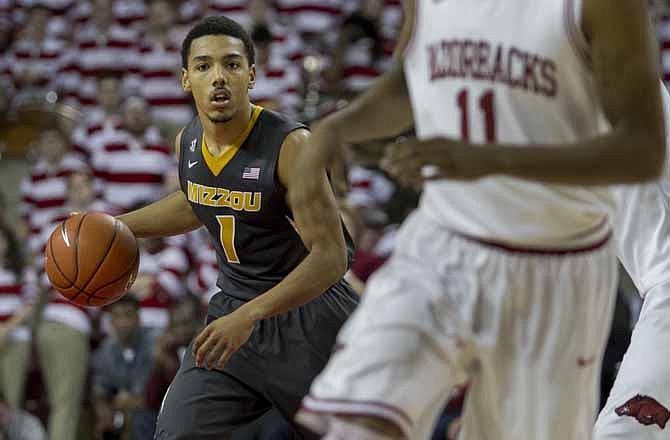 Missouri's Phil Pressey (1) looks to pass against Arkansas' defense during the second half an NCAA college basketball game in Fayetteville, Ark., Saturday Feb. 16, 2013. Arkansas defeated Missouri 73-71.
