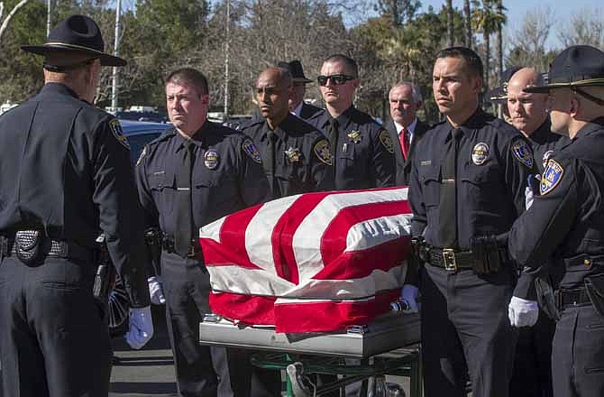 This Feb. 13, 2013 photo shows Riverside Police officers carrying the casket of fellow officer Michael Crain during his burial ceremony at the Riverside National Cemetery in Riverside, Calif. The 34-year-old Crain was ambushed in his patrol car on Feb. 7. Authorities believe the shooter was ex-Los Angeles policeman Christopher Dorner. 