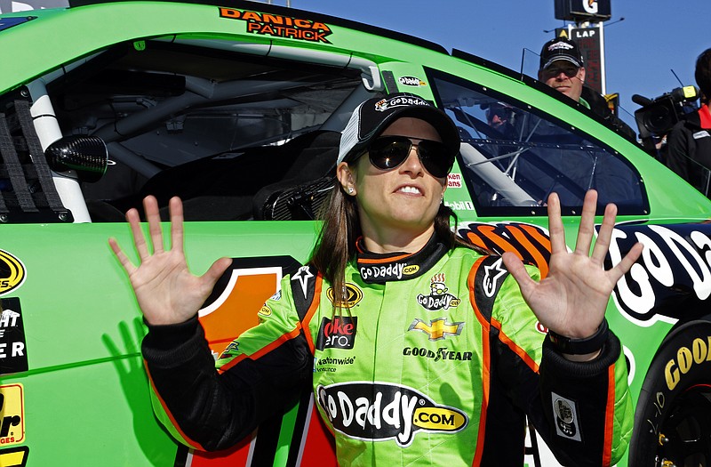 Danica Patrick gestures to photographers Sunday as she poses by her car after winning the pole during qualifying for the Daytona 500 at Daytona International Speedway in Daytona Beach, Fla.