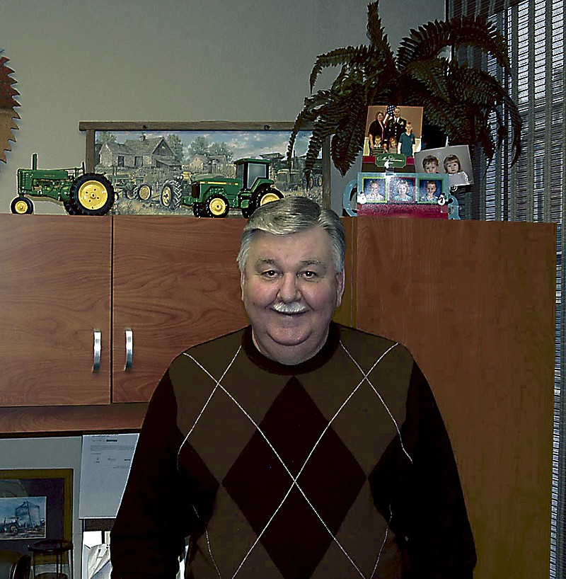 Democrat photo / David A. Wilson
Joe Allen in his office at People's Bank. behind him can be seen evidence of his outside interests - photos of family members and model farm tractors.