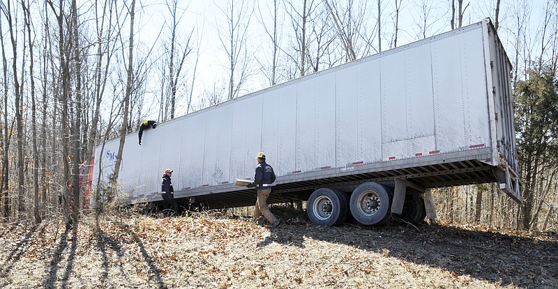 Tow Pro Wrecker Service operators were busy securing the trailer and shoring up support for it as they attached cables and straps to the trailer to pull out a tractor-trailer after it ran off the road and about 100 feet into the woods off eastbound U.S. 50, between Eastland Drive and Schott Road.