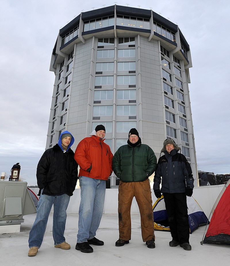 From left, Lt Charles Davis of the Department of Corrections, Corp. Mike Halford of the Missouri Highway Patrol, Capt. John Wheeler of the Cole County Sheriff's Department and Sgt. Randy Werner of the Jefferson City Police Department take a group photo below the Doubletree Hotel tower as they get set for their overnight "Freezin' for a Reason" stay atop the hotel's pool house on Wednesday while raising money for Special Olympics.