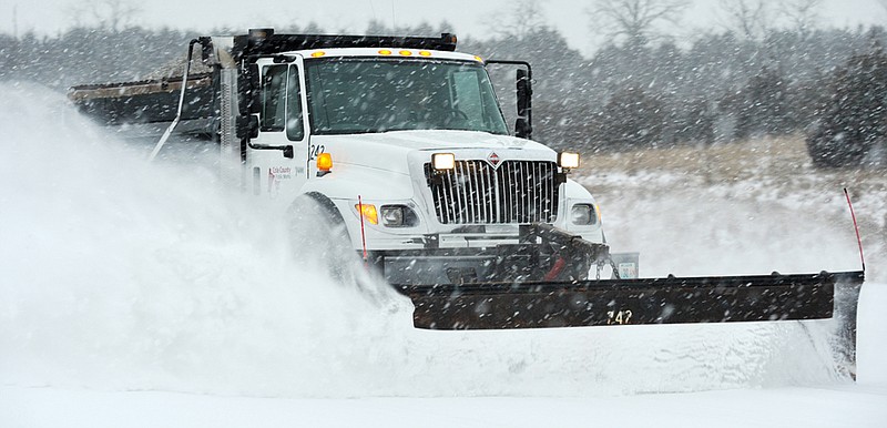 A Cole County Public Works operator cleans the morning's accumulation from Missouri 179. The expected winter storm dumped about twice as much snow as predicted, keeping road crews extra busy. Crews will continue to plow today and use chemicals to help  melt the snow and clean up streets.