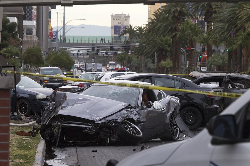 Police rope off the scene of a shooting and multi-car accident early Thursday on the Las Vegas Strip in Las Vegas. Authorities say at least one person in a Range Rover shot at people in a Maserati that then crashed into a taxi cab. The taxi cab burst into flames, and the driver and passenger were killed. The male driver of the Maserati also died, and his passenger was shot.