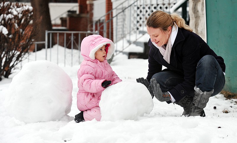 Three-year-old Eva Allen and her mom, Jacqueline Acton, spent part of Tuesday afternoon building a snowman in the front yard of their High Street apartment. It was the first time either of them built one and Jacqueline was enjoying every moment of the activity with her young daughter. 