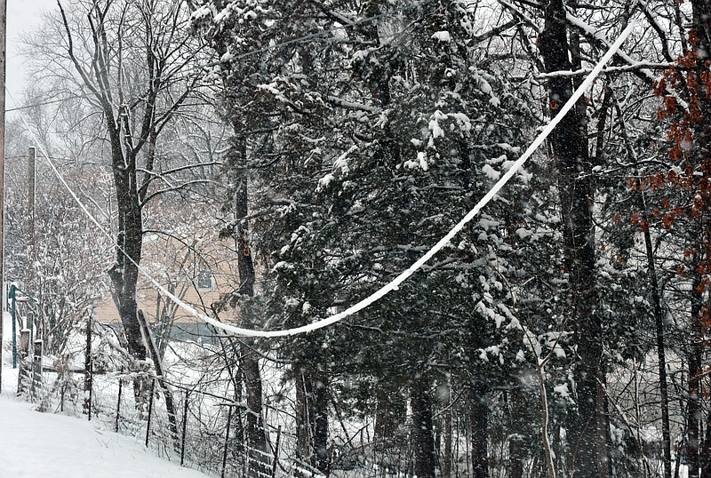 Snow accumulation on utility lines caused them to sag and some to snap Tuesday. There were power outages in the county and traffic on U.S. 54 was delayed after a power line fell across the highway. 