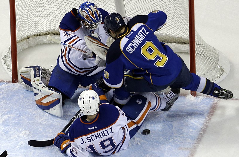 Jaden Schwartz of the Blues skates past the puck as Oilers goalie Devan Dubnyk and defenseman Justin Schultz try to defend during Friday night's game in St. Louis.