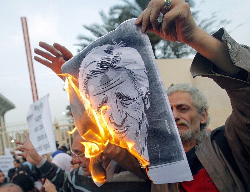 Egyptian activists burn a poster depicting U.S. Secretary of State John Kerry during a protest held Saturday outside the Egyptian foreign ministry in Cairo, Egypt. Cairo is the sixth leg of Kerry's first official overseas trip and begins the Middle East portion of his nine-day journey. 