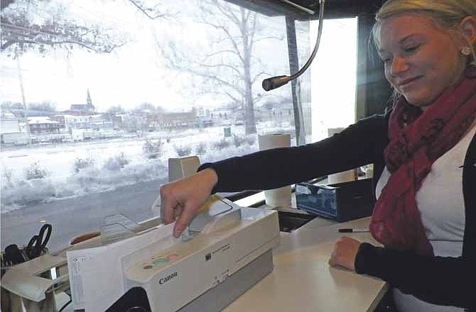 Central Bank teller Rachel Seidel spends just a few minutes scanning checks into the bank's system. The bank has seen the check volume decline substantially. A whole room once devoted to separating checks has been replaced by this small desktop scanner.