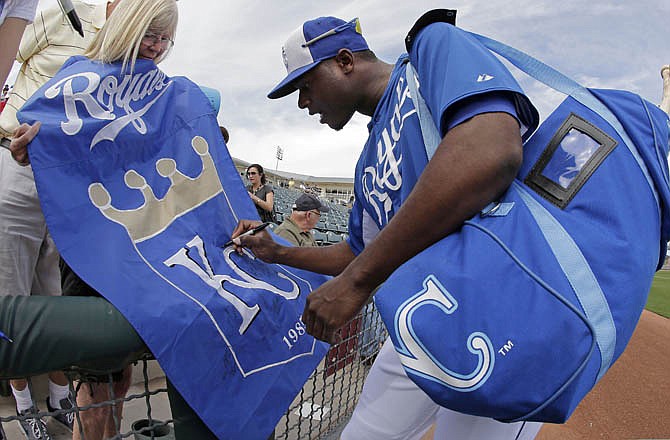 Royals outfielder Lorenzo Cain signs a banner for Donna Miles, from Knob Noster, before Tuesday's game against the Athletics in Surprise, Ariz.