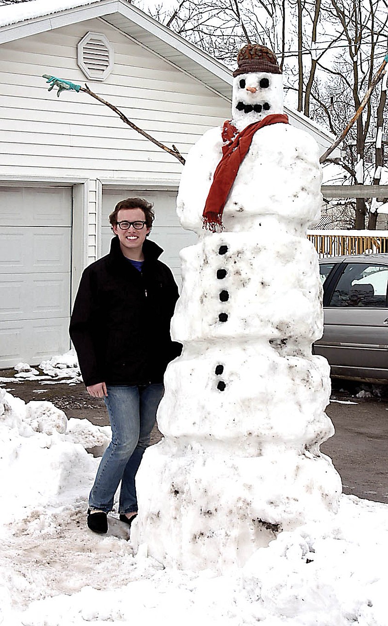 Shane Sneed with the first snowman he has ever built. Sneed, a sophomore at California High School grew up in south Texas and moved to California only a few weeks ago. He really enjoys the snow. In Texas, the most snow he has ever seen is no more than an inch.