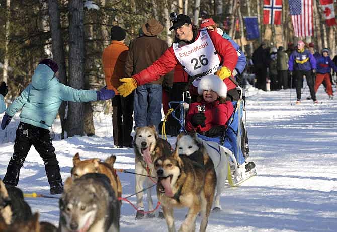 Jan Steves of Edmonds, Wash. greets a fan on the trail adjacent to Wesleyan Drive during the ceremonial start of the Iditarod Trail Sled Dog Race on March 2 in Anchorage, Alaska. The competitive portion of the 1,000-mile race began Sunday in Willow, Alaska.