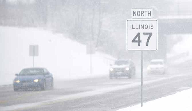 Visibility along Route 47 in the Chicago suburb of Lily Lake, Ill. is very limited as wet snow continued to fall during a snow storm on Tuesday.