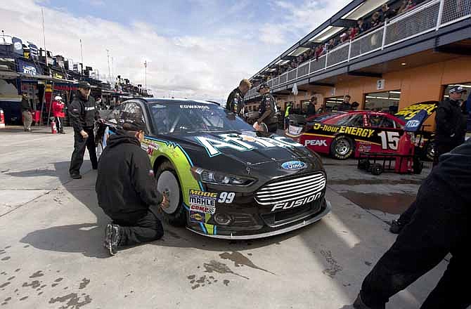 The pit crew for Carl Edwards prepares his No. 99 car for a template check before qualifying for the NASCAR Sprint Cup Series auto race, Friday, March 8, 2013 in Las Vegas.