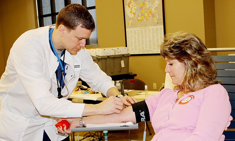 Paula Peeper of Williamsburg donates blood Saturday at the Callaway Electric Cooperative in Fulton during a Red Cross blood drive. Drawing blood is Red Cross employee Clay Grempel of Columbia. Peeper is a regular blood donor who has given blood more than 30 times.