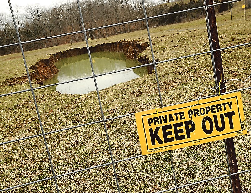 Ernest Hartenstein has been forced to place fence panels and warning signs around the perimeter of a growing sinkhole on his farmland near the intersection of Zion Road along Route C. Hartenstein filled in the sinkhole after it formed last summer, but recent rain and snowmelt have brought it back and accelerated the hole's growth.
