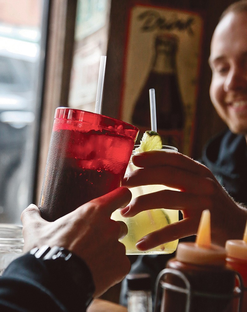 Customers at Brother Jimmy's BBQ call cheers with 24-ounce, left, and 16-ounce beverages, in New York. New York City's groundbreaking limit on the size of sugar-laden drinks has been struck down by a judge shortly before it was set to take effect. The restriction was supposed to start Tuesday and would have prohibited selling non-diet soda and some other sugary beverages in containers bigger than 16 ounces. 