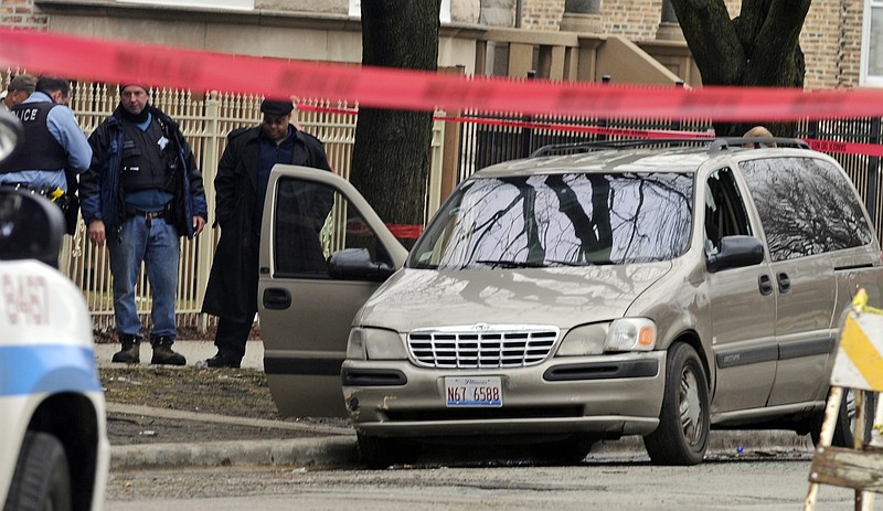 Chicago police investigate at the scene of a shooting Monday where 6-month-old Jonylah Watkins, was shot five times while her father was changing her diaper in a parked minivan in Chicago's Woodlawn neighborhood. The van can be seen with the window shattered from the shooting.