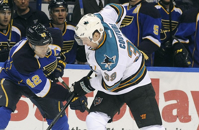 The Blues' David Backes (42) battles with the Sharks' Logan Couture for possession of the puck in the first period of Tuesday's game in St. Louis.