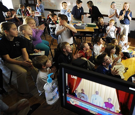Students from Brenda Raymer's 4th grade class at St. Peter Interparish School gather with kindergartners from Judy Heinrich's and Kathy Surface's classes as they clap and cheer. The classes were watching a live broadcast from Vatican City as Cardinal Jorge Mario Bergoglio of Argentina, now known as Pope Francis, addresses the gathered masses in St. Peter's Square and television audiences around the world from the central balcony of St. Peter's Basilica following his election as the 266th pontiff of the Roman Catholic Church by the College of Cardinals on Wednesday.