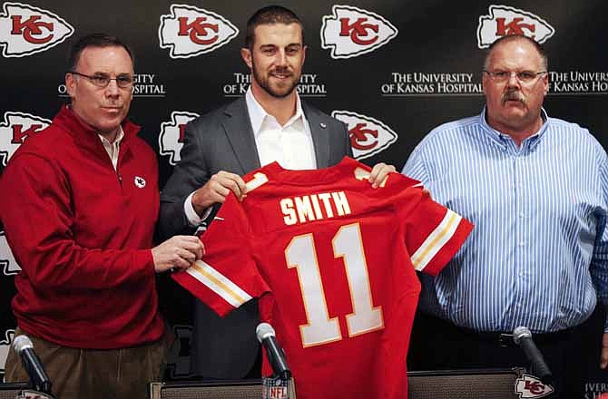 Kansas City Chiefs general manager John Dorsey, left, stands with head coach Andy Reid, right, and newly-signed quarterback Alex Smith following an NFL football news conference at the team's practice facility in Kansas City, Mo., Wednesday, March 13, 2013. 