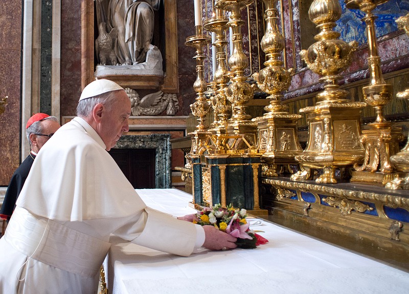 Pope Francis puts flowers on the altar Thursday inside St. Mary Major Basilica, in Rome. Pope Francis opened his first morning as pontiff by praying at Rome's main basilica dedicated to the Virgin Mary, a day after cardinals elected him the first pope from the Americas in a bid to revive a Catholic Church in crisis and give it a preacher with a humble touch. 