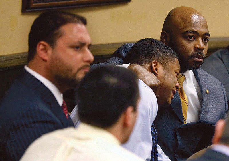 Defense attorney Walter Madison, right, holds his client, 16-year-old Ma'Lik Richmond, second from right, while defense attorney Adam Nemann, left, sits with his client Trent Mays, foreground, 17, as Judge Thomas Lipps pronounces them both guilty on rape and other charges after their trial in juvenile court in Steubenville, Ohio.