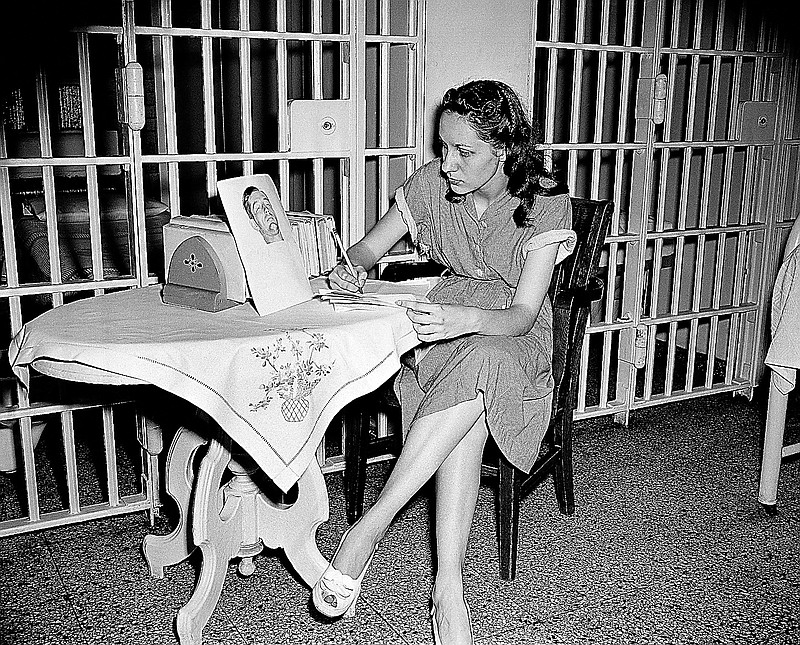In a 1949 photo, Ruth Steinhagen, 19, writes notes for her life history in Cook County Jail in Chicago. At the table she has a photograph of Philadelphia Phillies first baseman Eddie Waitkus, who she shot at a Chicago hotel.