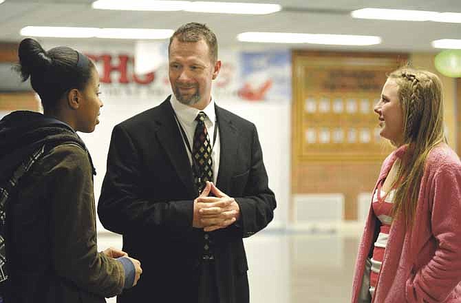 Jefferson City High School principal Jeff Dodson visits with Kezia Martin, left, and Tayler LePage after school Tuesday and finds out the details of their recent basketball activity.