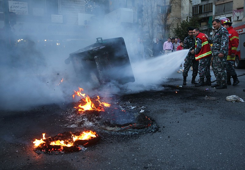 Lebanese firefighters extinguish burned tires and garbage containers that were set on fire by protesters, after two Sunni Muslim sheikhs at dar al-Fatwa, Lebanon's highest Sunni Authority, were attacked by Shiite men late Sunday, in Beirut, Lebanon.
