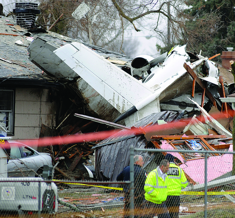 South Bend firefighters work a home Monday in South Bend, Ind., where a plane crashed Sunday. The plane damaged homes, as well as caused injuries, including at least two fatalities.