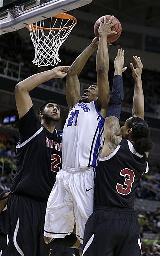 Saint Louis' Dwayne Evans (center) puts up a shot between New Mexico State's Sim Bhullar (left) and Remi Barry during Thursday's game.