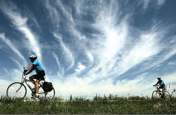 A pair of cyclists travel along a wide-open stretch of the Katy Trail near the trail's western terminus at Clinton, Mo, in 2006. Photographers and artists are invited to take part in a Capital Arts exhibit showcasing the many miles of trails surrounding Jefferson City. 